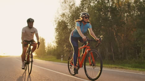 A-man-and-a-woman-ride-sports-bikes-on-the-highway-at-sunset-in-gear-and-protective-helmets-in-slow-motion-120-fps.